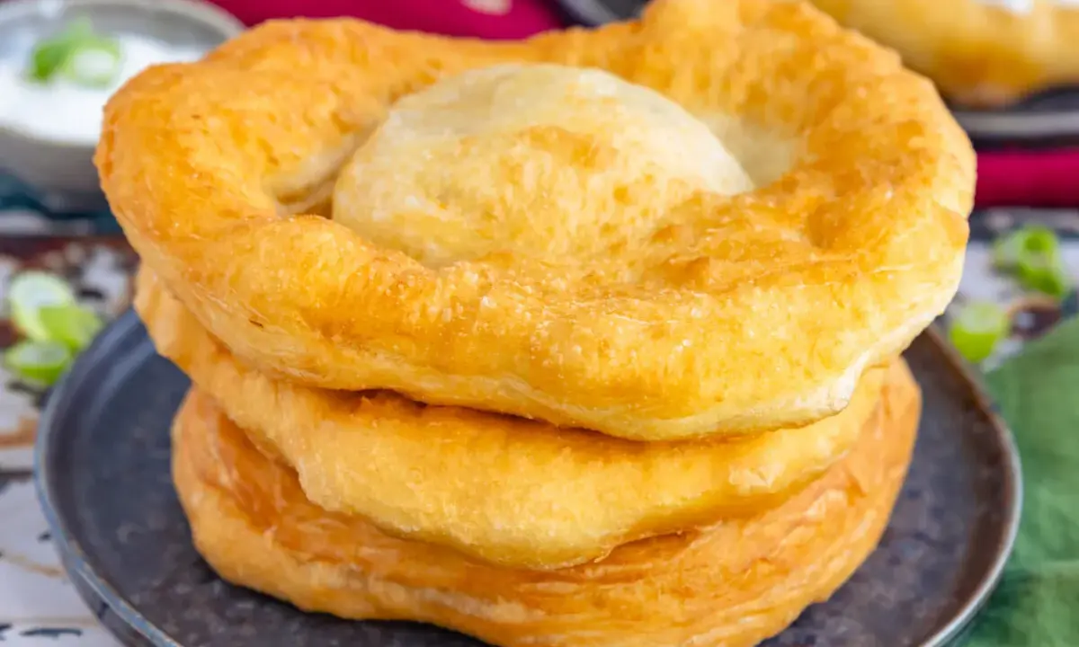 Goldbraune, fluffige Langos stapeln sich auf einem Teller. Ein köstliches Langos Rezept für zu Hause.