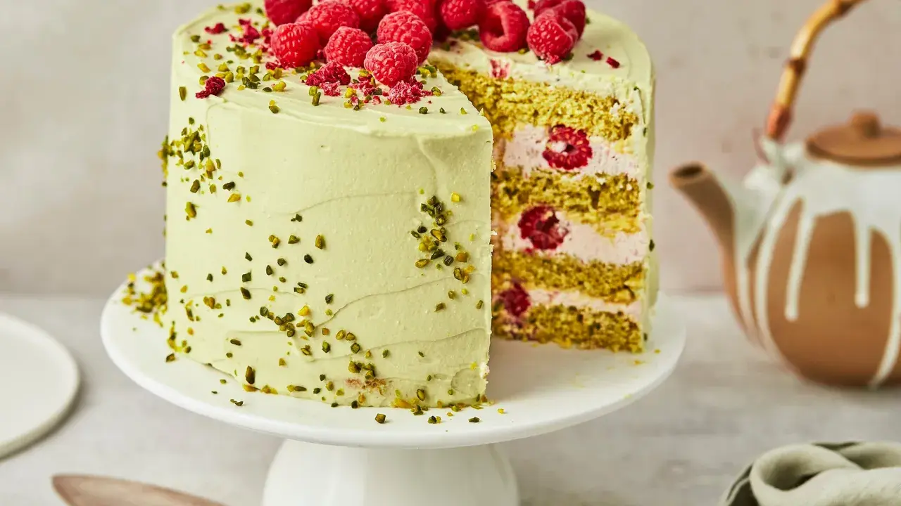 Himbeer-Pistazien-Torte mit frischen Beeren und grüner Creme, ein köstlicher Genuss.