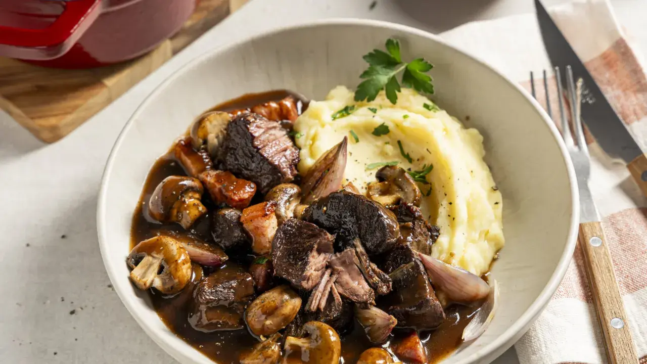Boeuf Bourguignon mit cremigem Kartoffelpüree als Beilage, garniert mit Petersilie. Ein Festmahl!