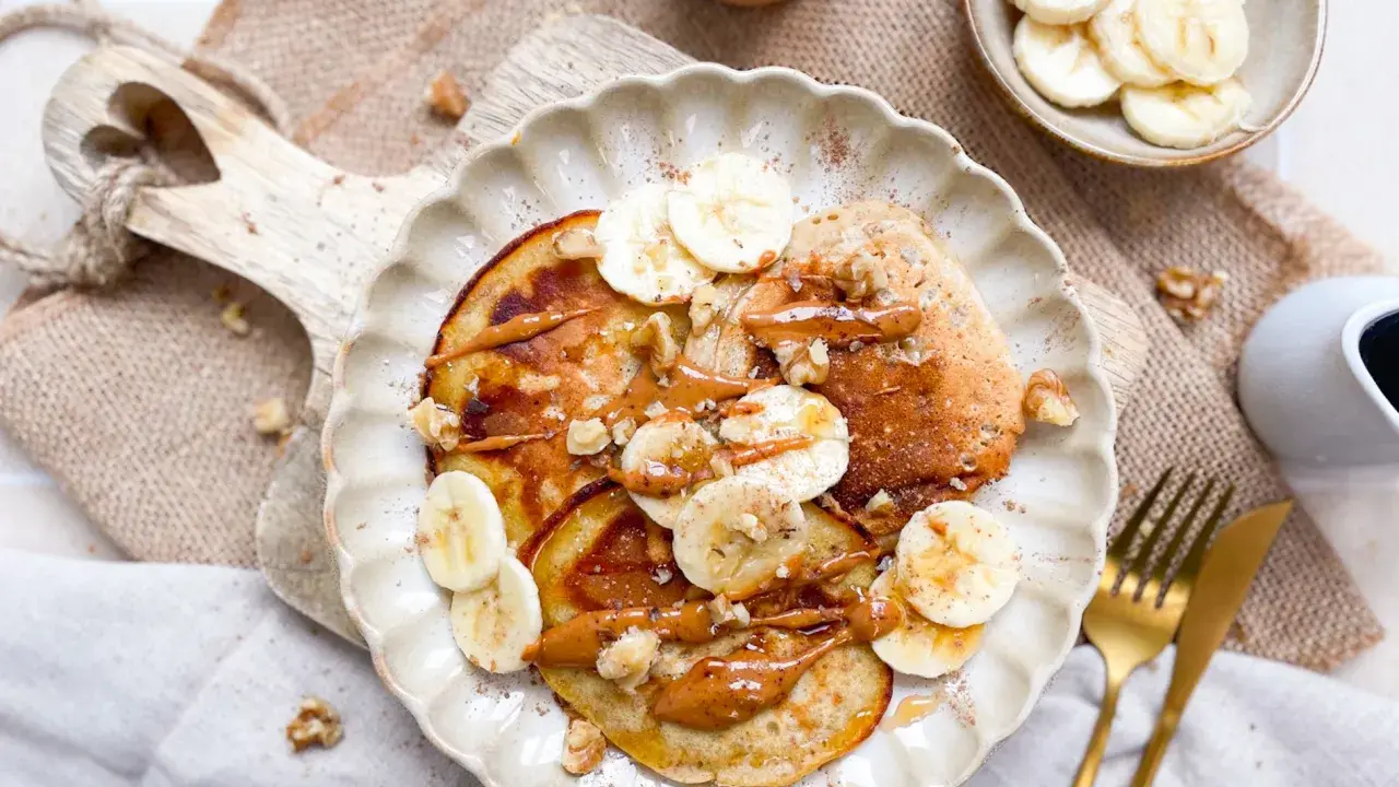 Leckere bananen pancakes ohne ei, garniert mit Bananenscheiben, Nüssen und einer cremigen Sauce. Ein Genuss für jeden Morgen!