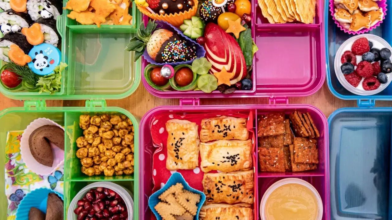Bunte Bento-Boxen mit Sushi, Obst, Keksen und Gebäck. Perfekt für to go rezepte und kleine Entdecker.