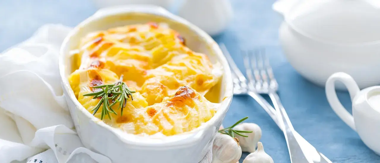 Ein goldbrauner Kartoffelauflauf mit Rosmarin und Knoblauch, bereit zum Servieren. Ein köstliches Auflauf Rezept für jeden Anlass.