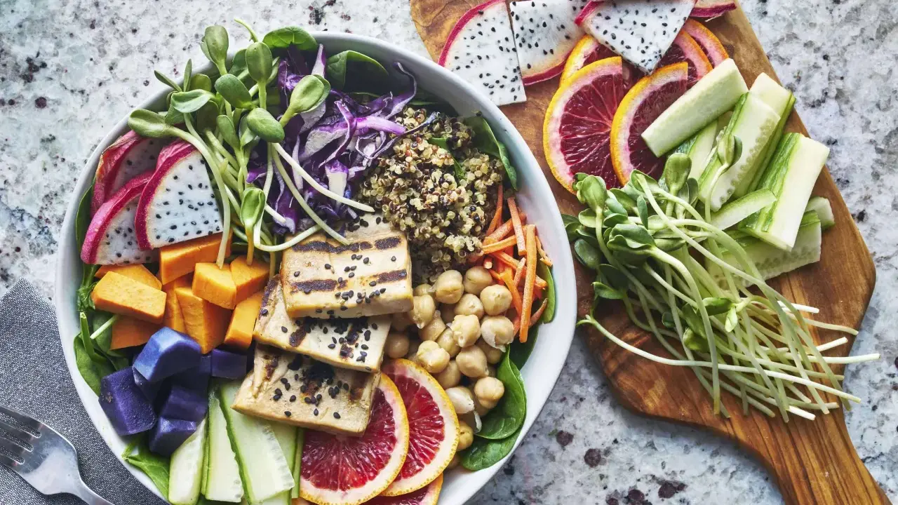 Bunter Buddha Bowl mit Tofu, Quinoa, Süßkartoffeln, Drachenfrucht und Sprossen – perfekt für das leichte essen an warmen tagen.