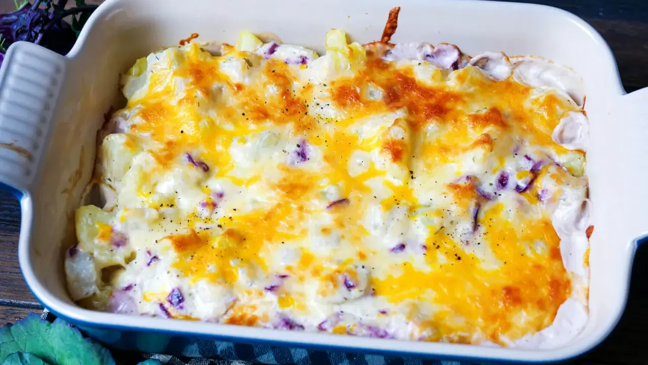 Herzhaftes rezept kohlrabi-auflauf vegetarisch mit geschmolzenem Käse und Kräutern in einer Auflaufform.