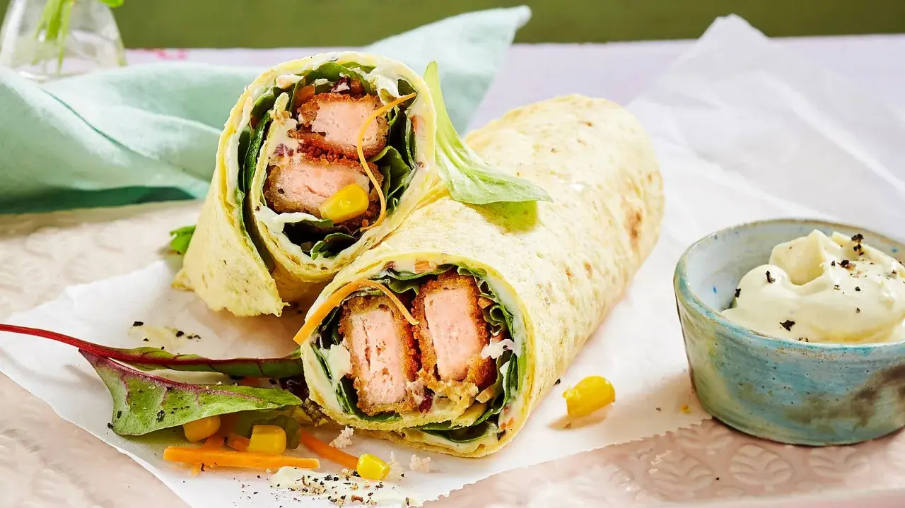 Leckere Wraps selber machen: knuspriger Lachs, frischer Salat, Mais und Karotten in einem Tortilla-Wrap, dazu ein Dip.