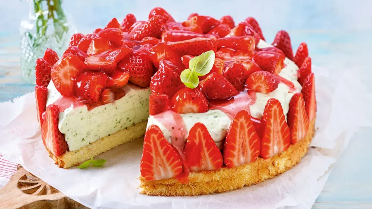 Erdbeer Basilikum Torte: Ein saftiger Biskuitboden, umhüllt von frischen Erdbeeren, mit einer cremigen Füllung, verfeinert mit Basilikum und Erdbeersauce.