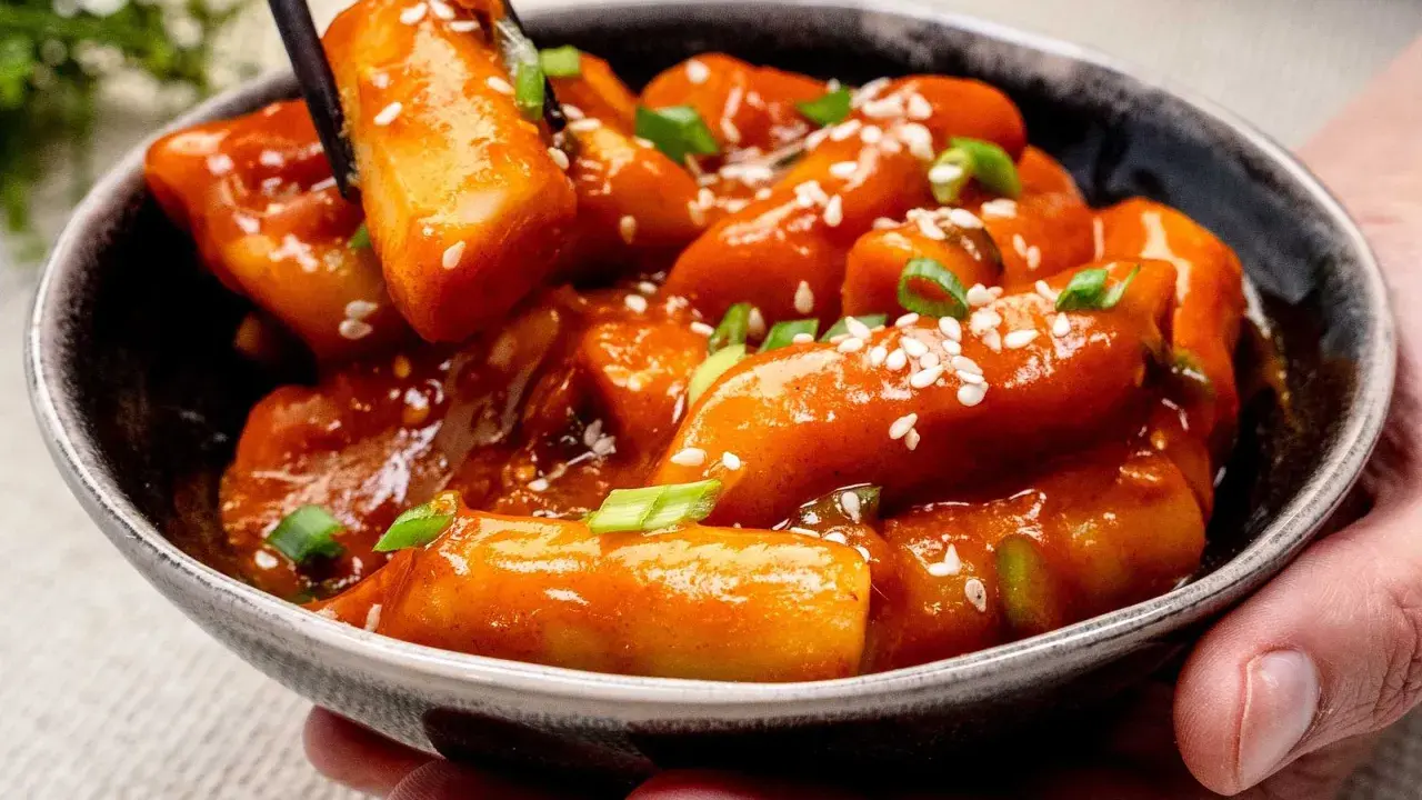 Tteokbokki in einer Schüssel, garniert mit Frühlingszwiebeln und Sesam. Diese tollen Rezepte sind ein Genuss!
