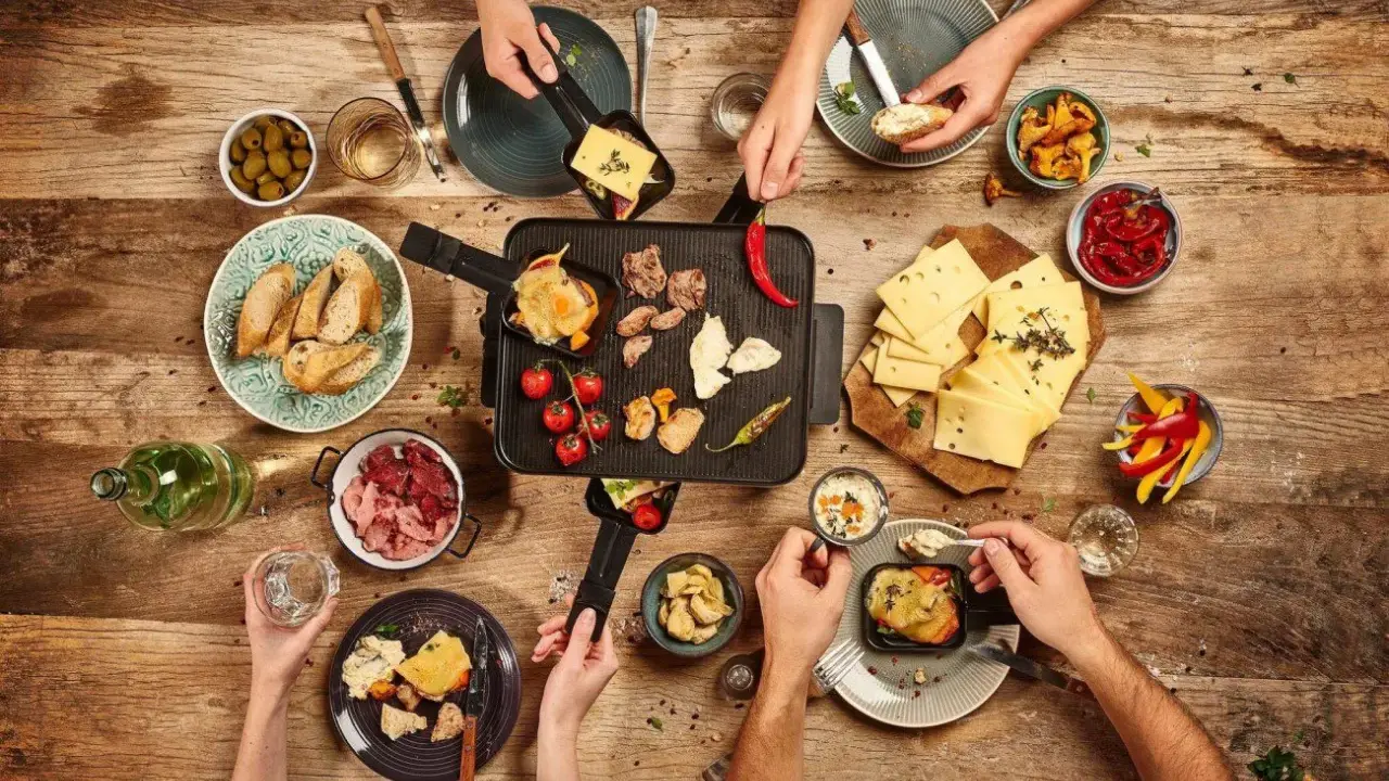 Raclette-Abend: Käse schmilzt, Fleisch brät, dazu Brot, Oliven, Paprika und Pilze – so vielfältig, was man zu Raclette essen kann!