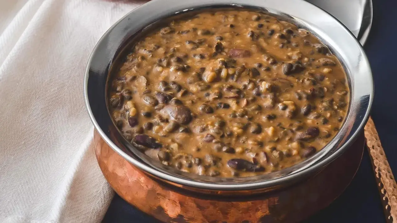 Cremiges Dal Makhani in einer Kupferschale, serviert mit einem Löffel.