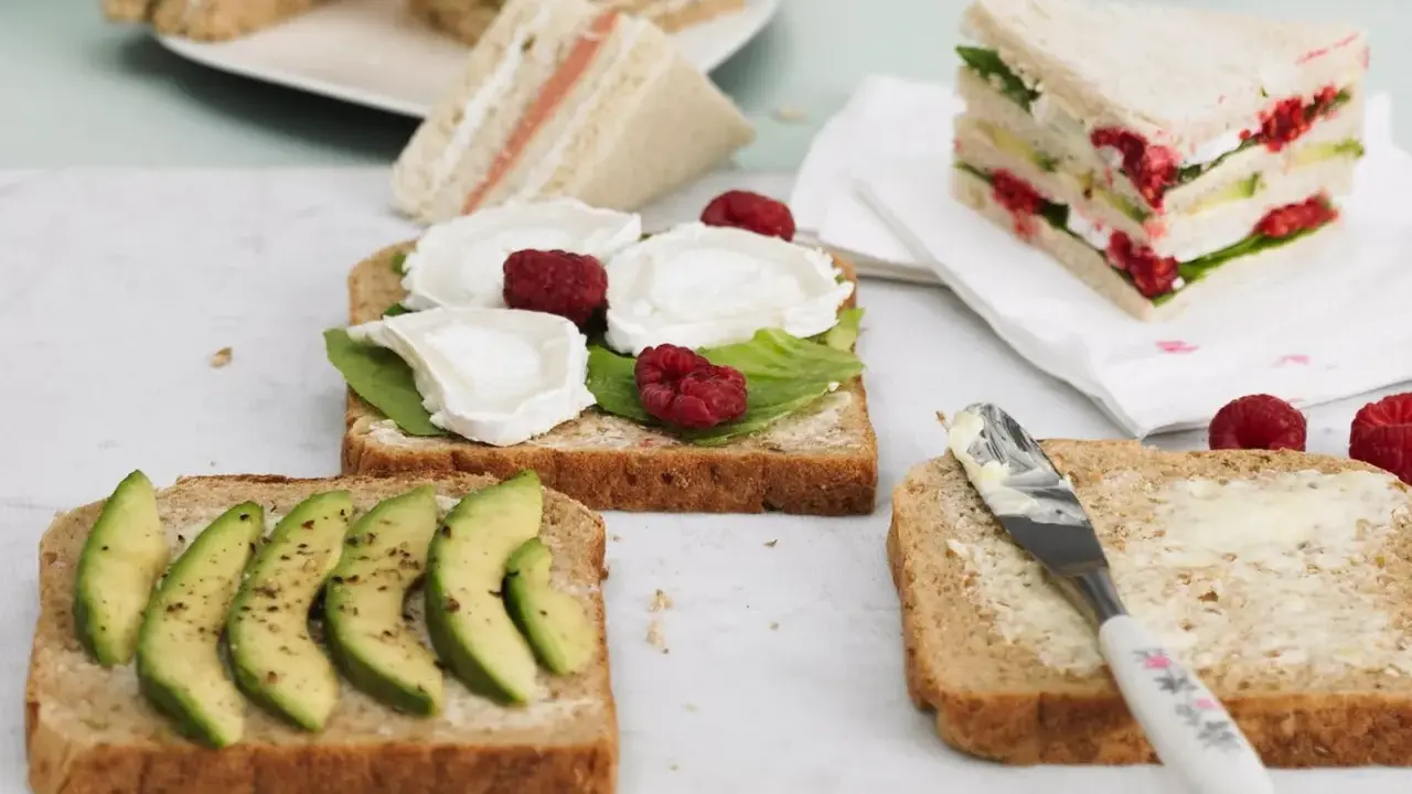 Schnelles Essen ohne Kochen: Mehrere belegte Brote mit Avocado, Ziegenkäse und Himbeeren, bereit zum Genuss.