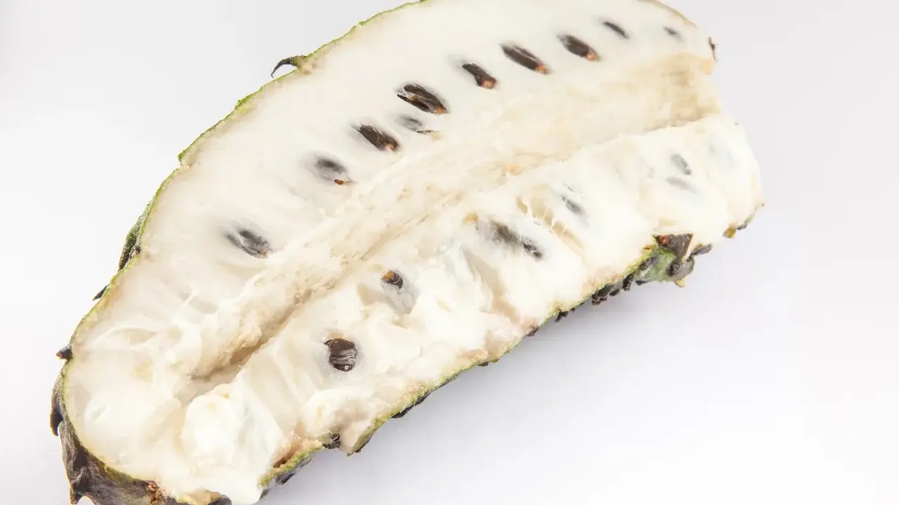 Aufgeschnittene Soursop-Frucht mit weißem Fruchtfleisch und dunklen Kernen, bereit für den Genuss.