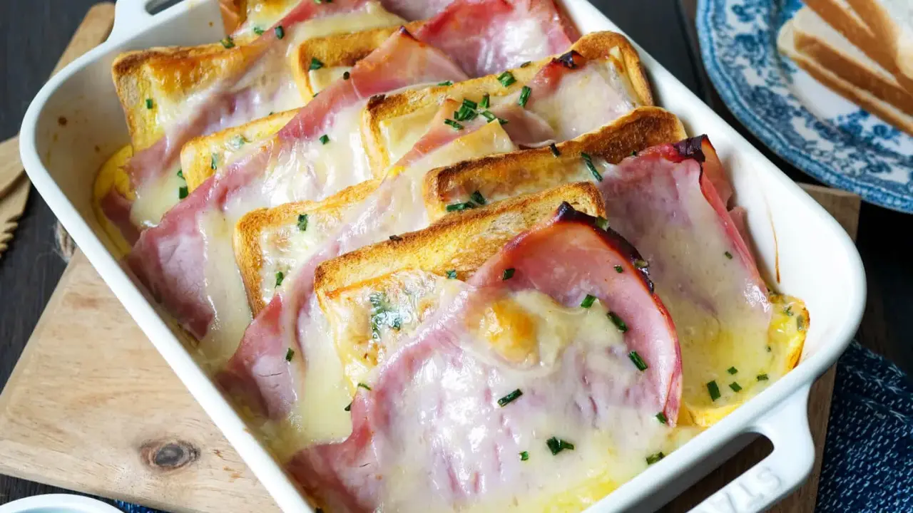 Herzhafte Toast-Rezepte: Geröstetes Brot mit Schinken und geschmolzenem Käse, bestreut mit Schnittlauch, in einer Auflaufform.