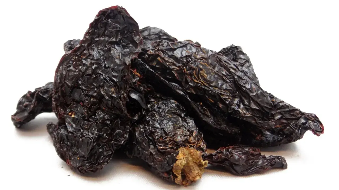 Getrocknete, dunkelrote Chilis, die Frage "was ist Chipotle?" beantwortend. Sie sind die Basis für rauchige Saucen und Gewürze.