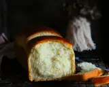 Ein frisch gebackenes Brioche-Brot, das auf einem Rost abkühlt. Die goldbraune Kruste und die weiche, helle Krume lassen das brioche rezept gelingen.