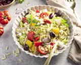 Ein bunter, schneller Kritharaki-Salat mit Tomaten, Gurken, Paprika, roten Zwiebeln, Oliven und Feta.