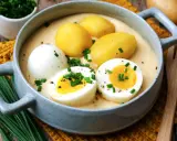 Senfeier rezept: Herzhaftes Gericht mit pochierten Eiern, Kartoffeln und cremiger Senfsauce, garniert mit Schnittlauch.