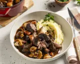 Boeuf Bourguignon mit cremigem Kartoffelpüree als Beilage, garniert mit Petersilie. Ein Festmahl!