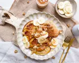 Leckere bananen pancakes ohne ei, garniert mit Bananenscheiben, Nüssen und einer cremigen Sauce. Ein Genuss für jeden Morgen!