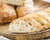 Frisch gebackene Ciabatta-Brote, aufgeschnitten auf einem Holzbrett. Dieses Ciabatta Rezept ergibt luftiges Brot mit knuspriger Kruste.