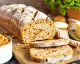 Frisch gebackenes Zwiebelbrot mit knusprigen Röstzwiebeln, bereit für ein köstliches Zwiebelbrot Rezept. Daneben Butter und frische Kräuter.