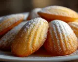 Ein Haufen goldbrauner Madeleines, bestäubt mit Puderzucker. Diese sehen aus wie die besten Madeleines, die man je probiert hat.