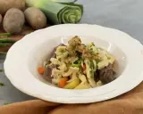 Herzhafter Gaisburger Marsch mit zarten Spätzle, Rindfleisch, Kartoffeln und Karotten, garniert mit Röstzwiebeln und Schnittlauch.