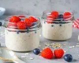 Zwei Gläser mit Overnight Oats, garniert mit frischen Himbeeren und Blaubeeren. Perfekt für ein leckeres, low carb Frühstück.