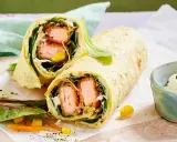 Leckere Wraps selber machen: knuspriger Lachs, frischer Salat, Mais und Karotten in einem Tortilla-Wrap, dazu ein Dip.
