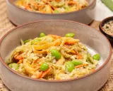 Ein cremiger asiatischer Salat mit knackigem Kohl, Karottenstreifen und Edamame, garniert mit Sesam.