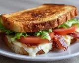 Knuspriges Sandwich im Airfryer mit geschmolzenem Käse, knackigem Speck, frischem Salat und Tomaten. Perfekt für eine schnelle Mahlzeit!