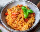 Herzhaftes serbisches Reisfleisch mit Paprika und Basilikum in einer rustikalen Schüssel, bereit zum Genießen.