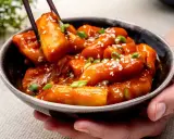 Tteokbokki in einer Schüssel, garniert mit Frühlingszwiebeln und Sesam. Diese tollen Rezepte sind ein Genuss!