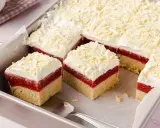 Schneeweiße Sahne und rote Fruchtschicht auf hellem Boden, bestreut mit weißer Schokolade. Ein köstlicher Frau Holle Kuchen, der zum Reinbeißen einlädt.