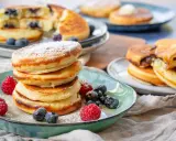 Fluffige Buttermilch Pancakes, mit Puderzucker bestäubt und garniert mit frischen Beeren. Ein Genuss für jeden Morgen!