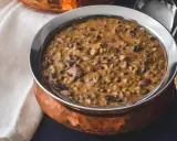 Cremiges Dal Makhani in einer Kupferschale, serviert mit einem Löffel.
