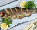 Saftige Lachsforelle im Backofen, garniert mit Zitrone und frischen Kräutern. Ein Genuss für Gaumen und Augen.