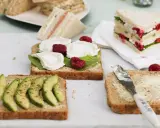 Schnelles Essen ohne Kochen: Mehrere belegte Brote mit Avocado, Ziegenkäse und Himbeeren, bereit zum Genuss.