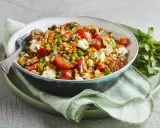 Ein bunter, gesunder rote Linsen Salat mit Tomaten, Feta und Nüssen, appetitlich in einer Schüssel serviert.