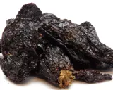 Getrocknete, dunkelrote Chilis, die Frage "was ist Chipotle?" beantwortend. Sie sind die Basis für rauchige Saucen und Gewürze.