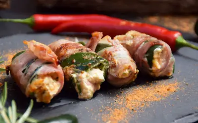 Gefüllte Jalapeños, umwickelt mit Speck, sind ein köstlicher Snack. Was sind Jalapeños? Kleine, grüne Chilis mit moderater Schärfe.