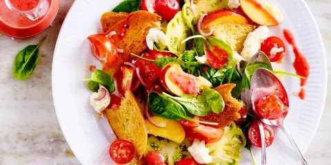 Bunter Salat mit Tomaten, Pfirsich, Brot und Käse – ein Fest für die Sinne und ein Beispiel für raffinierte Sommersalate.