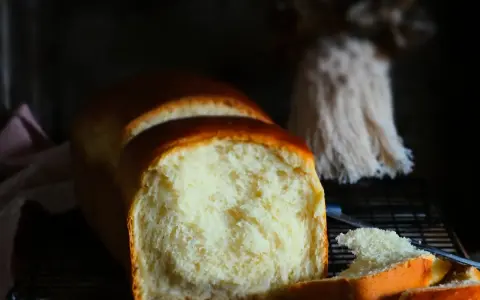 Ein frisch gebackenes Brioche-Brot, das auf einem Rost abkühlt. Die goldbraune Kruste und die weiche, helle Krume lassen das brioche rezept gelingen.