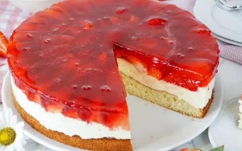 Ein saftiger erdbeerkuchen mit vanillepudding und einer glänzenden Erdbeer-Gelee-Schicht. Ein Stück ist bereits herausgeschnitten.