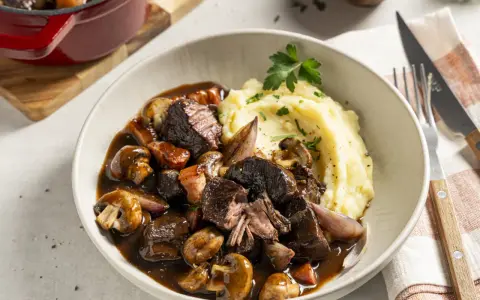 Boeuf Bourguignon mit cremigem Kartoffelpüree als Beilage, garniert mit Petersilie. Ein Festmahl!