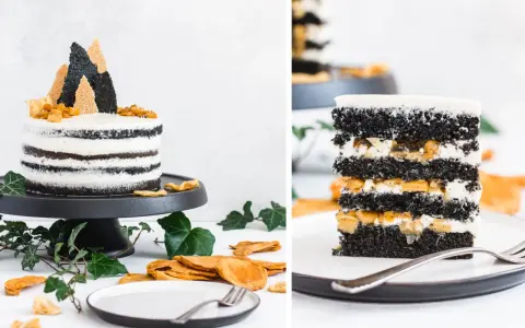 Schwarzer Sesam-Kuchen mit weißer Creme und Fruchtfüllung, inspiriert von schwarzen Sesam Rezepten. Ein Stück des Kuchens zeigt die Schichten.