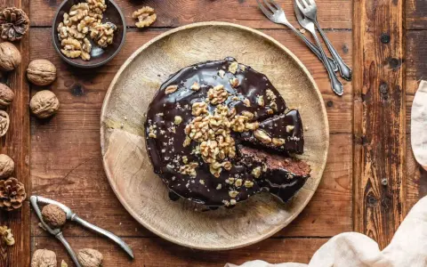 Saftiger Walnusskuchen ohne Mehl, glasiert mit Schokolade und garniert mit Walnüssen. Ein Genuss für alle Sinne!