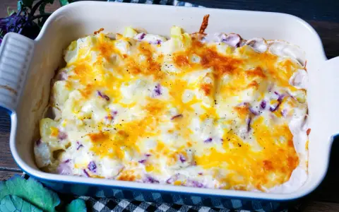 Herzhaftes rezept kohlrabi-auflauf vegetarisch mit geschmolzenem Käse und Kräutern in einer Auflaufform.