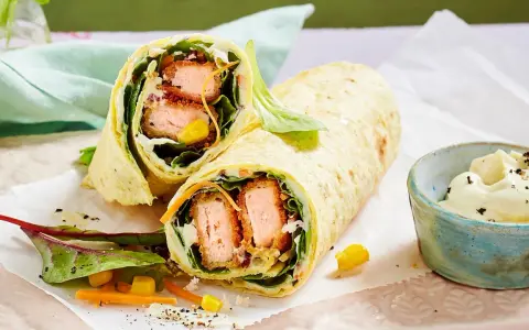 Leckere Wraps selber machen: knuspriger Lachs, frischer Salat, Mais und Karotten in einem Tortilla-Wrap, dazu ein Dip.