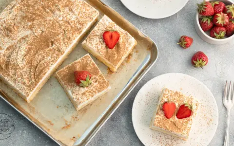 Saftiger Tres Leches Kuchen, bestreut mit Zimt und garniert mit frischen Erdbeeren. Ein Genuss für jeden Anlass.