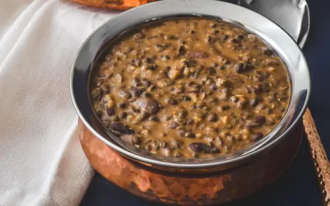Cremiges Dal Makhani in einer Kupferschale, serviert mit einem Löffel.